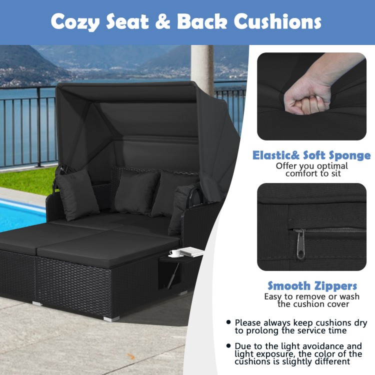 Close-up of soft black cushions on a patio rattan daybed with a retractable canopy, designed for outdoor comfort.