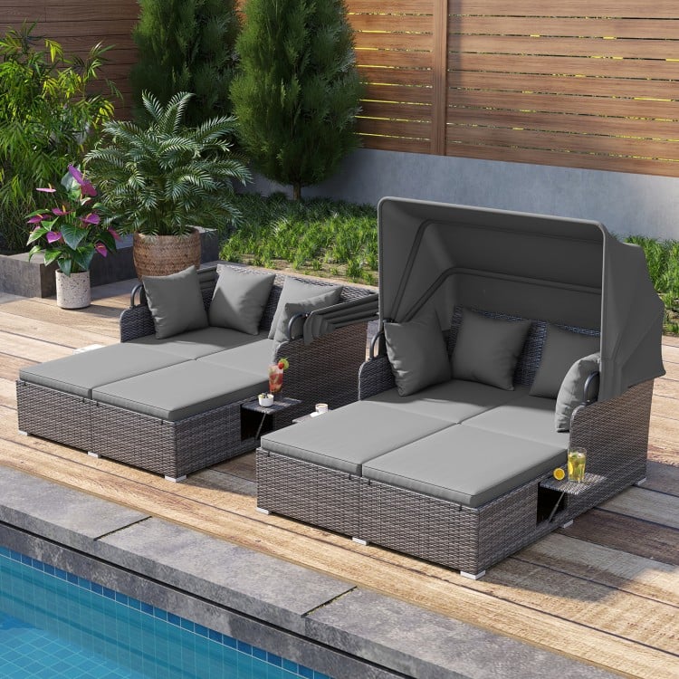 Patio rattan daybed with retractable canopy and side tables in mix gray, perfect for poolside relaxation.
