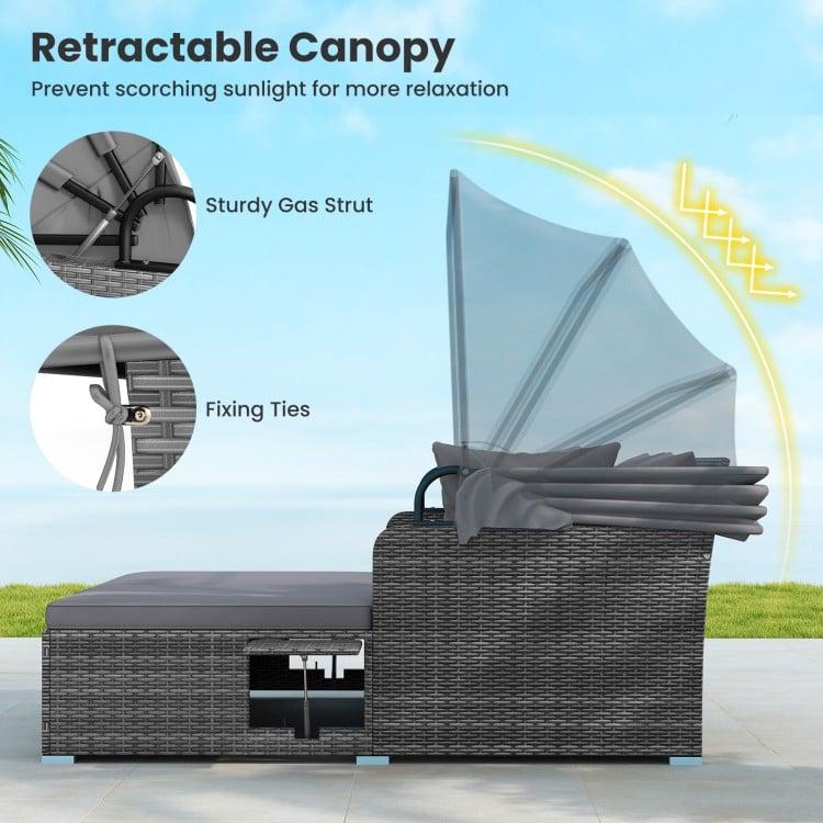 Patio rattan daybed with retractable canopy, featuring soft cushions and foldable side tables for outdoor relaxation.