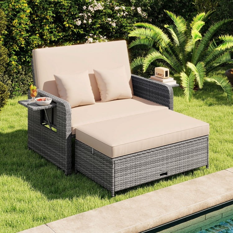 Patio wicker loveseat sofa with beige cushions, multipurpose ottoman, and retractable side tray for poolside relaxation.