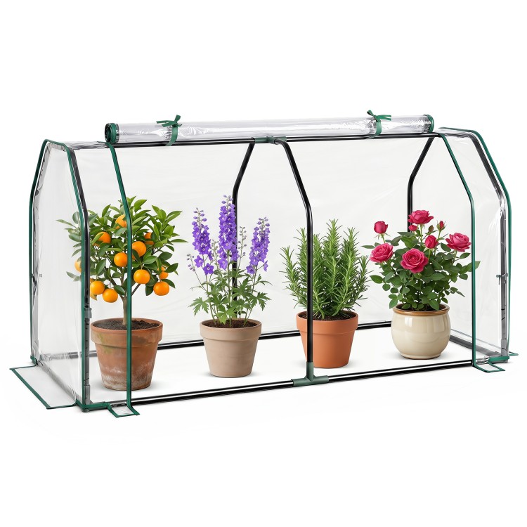 Portable mini greenhouse with PE cover and zippered door, ideal for protecting plants in backyard or garden settings.