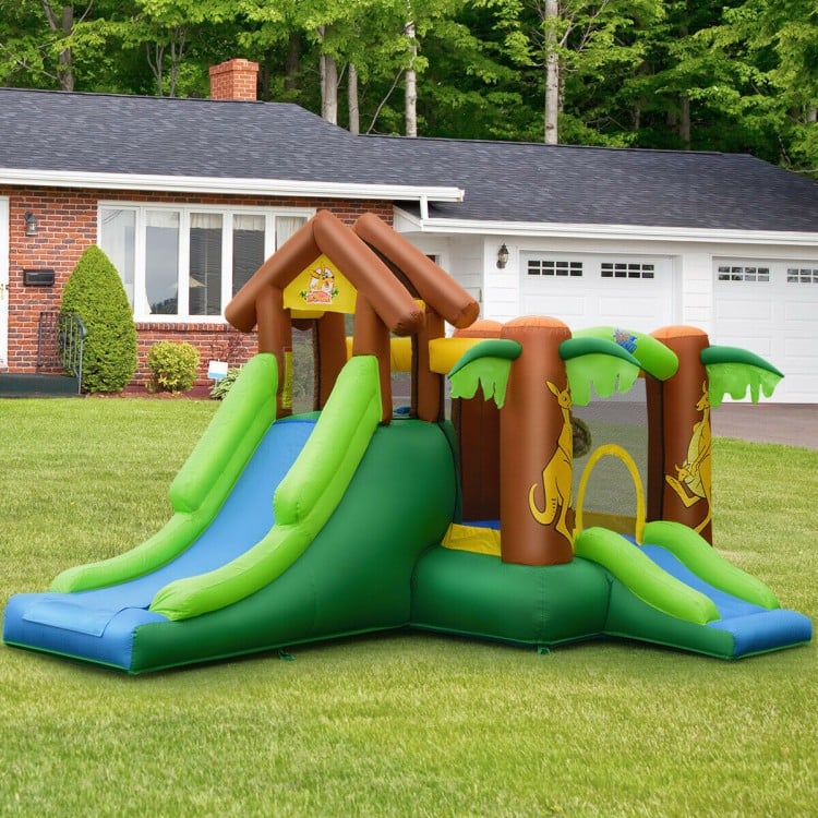 Kids inflatable jungle bounce house with two slides, climbing wall, and safety nets for outdoor fun.