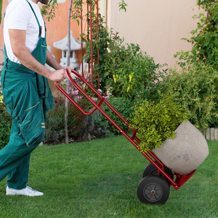 P-handle sack truck in red with 10-inch wheels, transporting a large potted plant for easy maneuvering in the garden.