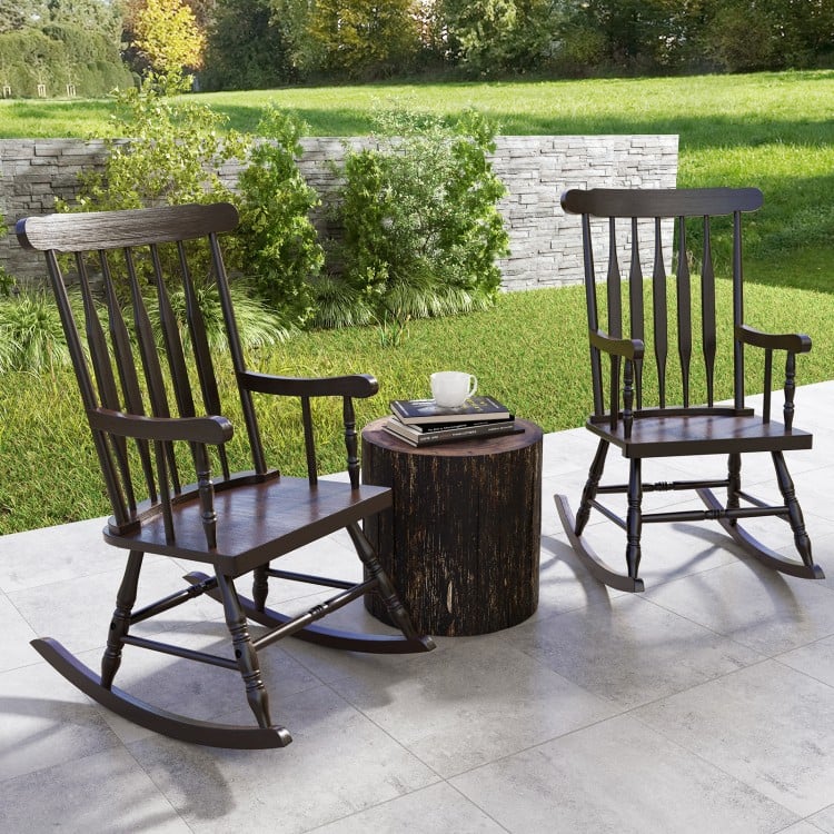 Two brown rocking chairs with solid rubber wood frames, placed on a patio for outdoor relaxation and comfort.
