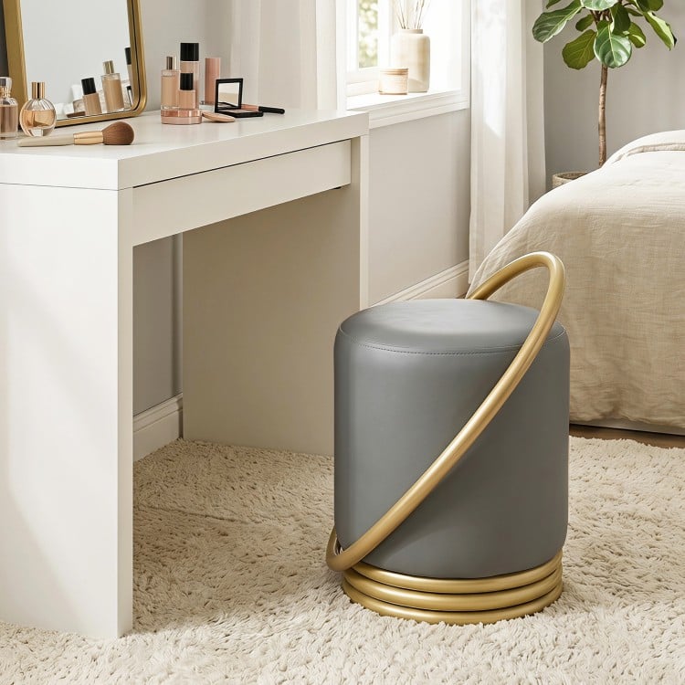Round grey faux leather vanity stool with gold halo design, perfect for makeup rooms or bedrooms, offering stylish comfort.