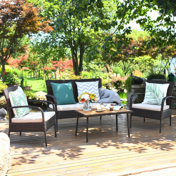 Cushioned wicker conversation set with acacia wood tabletop, perfect for outdoor patio or garden relaxation.