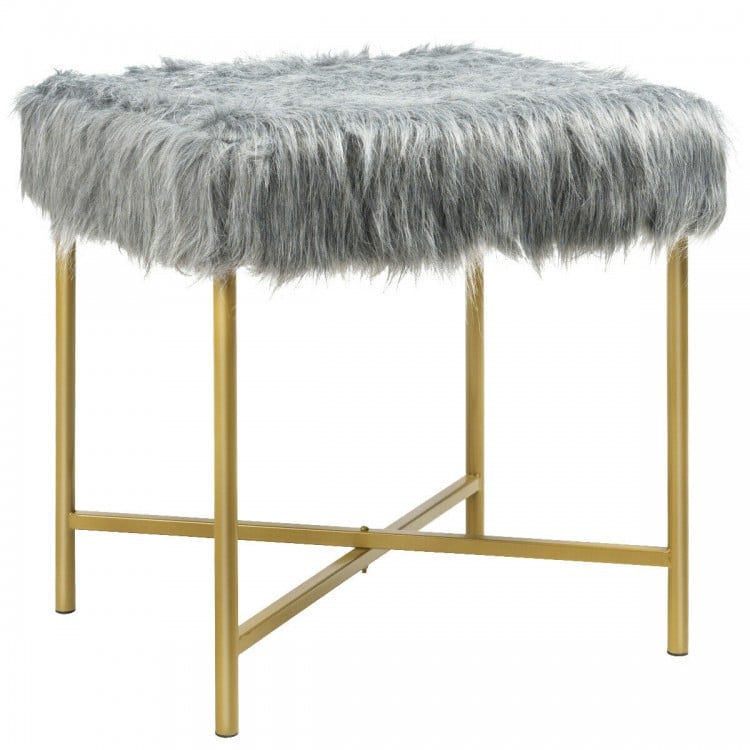 Close-up of gray faux fur ottoman stool with golden metal legs, showcasing its soft texture and stylish design for any.
