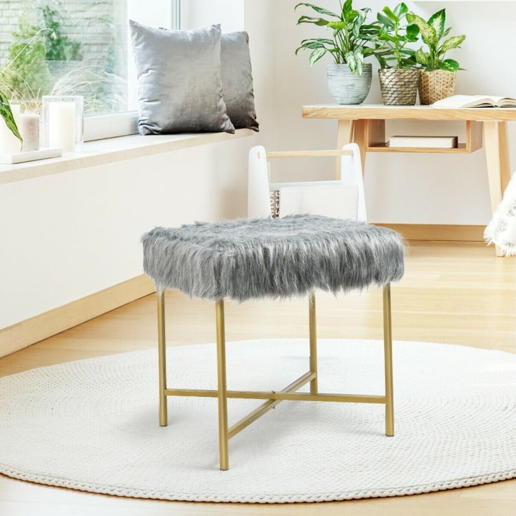 Gray faux fur decorative stool with golden metal legs, providing a stylish touch and comfort for small spaces.