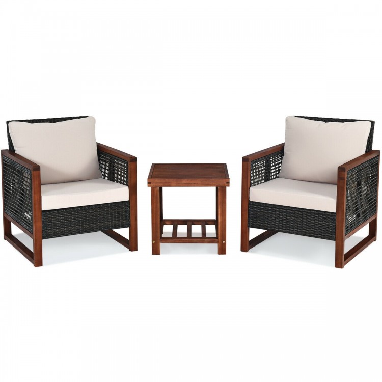Two beige cushioned patio wicker chairs with a wooden frame and a coffee table, perfect for outdoor relaxation.