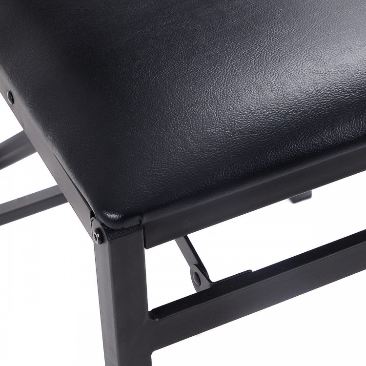Close-up of a black PU leather seat on a metal folding dining chair, featuring a durable steel frame for stability.