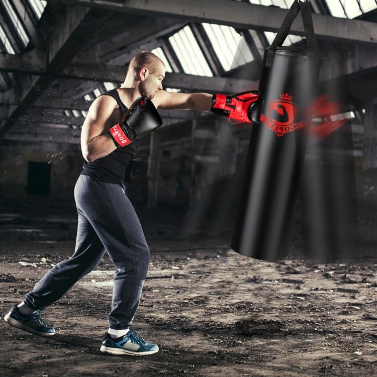 Boxer striking a filled punching bag set with boxing gloves for indoor workout and stress relief, featuring durable PVC.