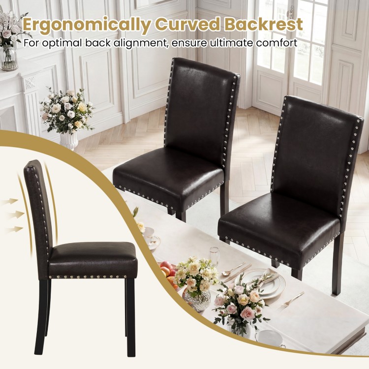 Set of two faux leather dining chairs with curved backs, nailhead accents, and solid wood legs for elegant kitchen.