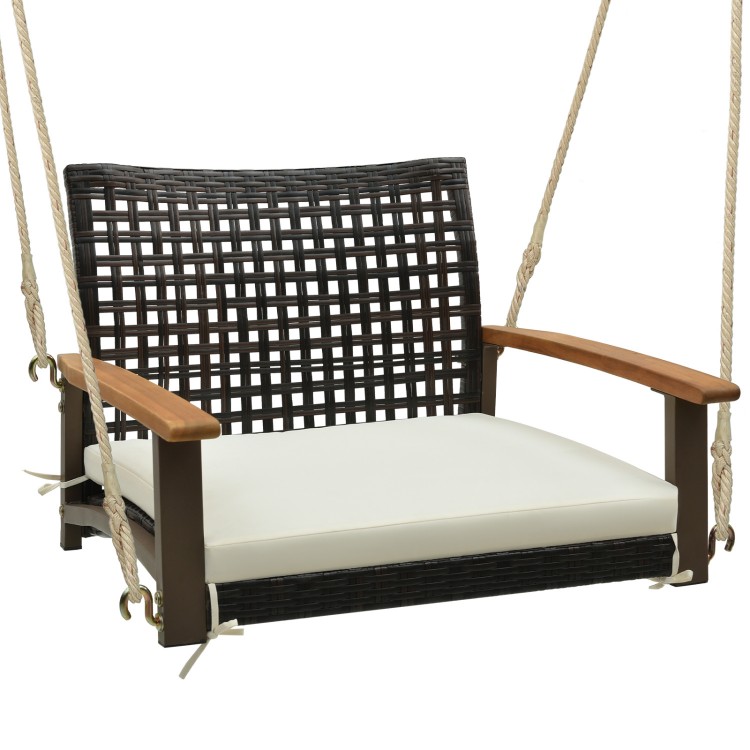 Single rattan porch swing with acacia wood armrests and white cushion, ideal for outdoor relaxation on the patio.