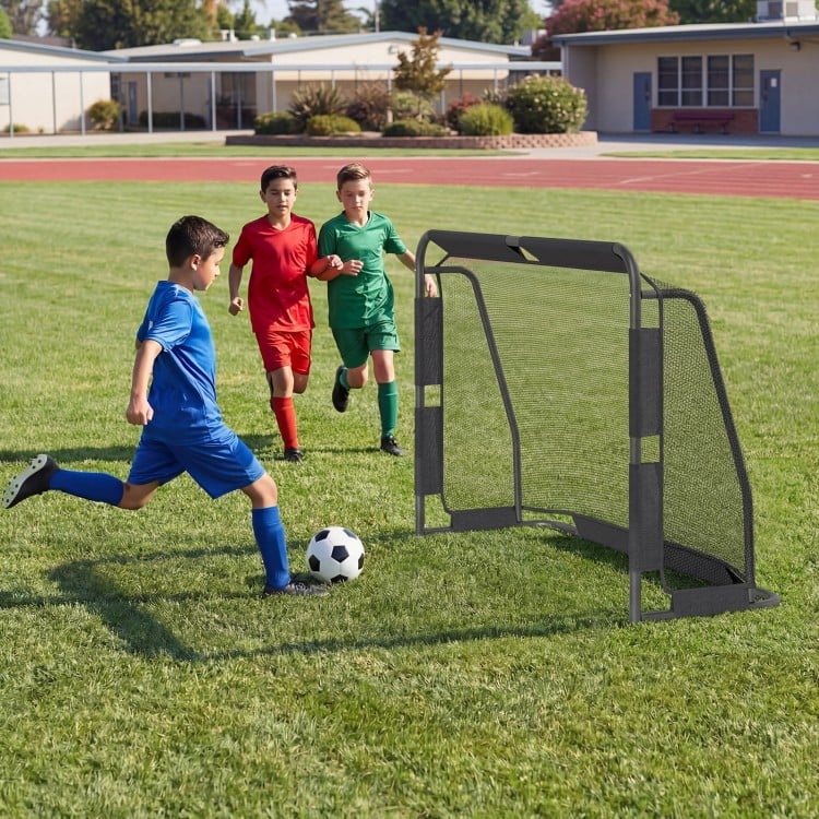 Kids playing soccer near a 6 ft x 4 ft metal frame goal post with net, perfect for backyard training and recreation.