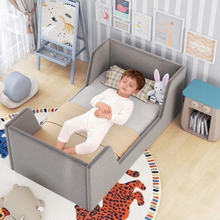 Gray soft velvet toddler bed frame with safety rails, featuring a child sleeping comfortably with plush toys.