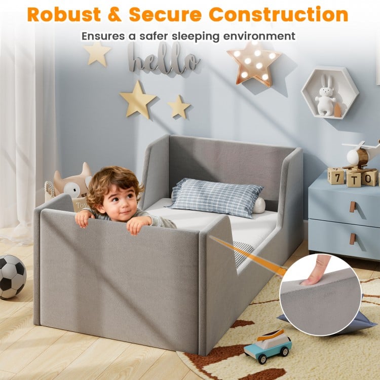Toddler bed frame in gray soft velvet with safety rails, featuring sturdy wooden slats for stability and comfort.
