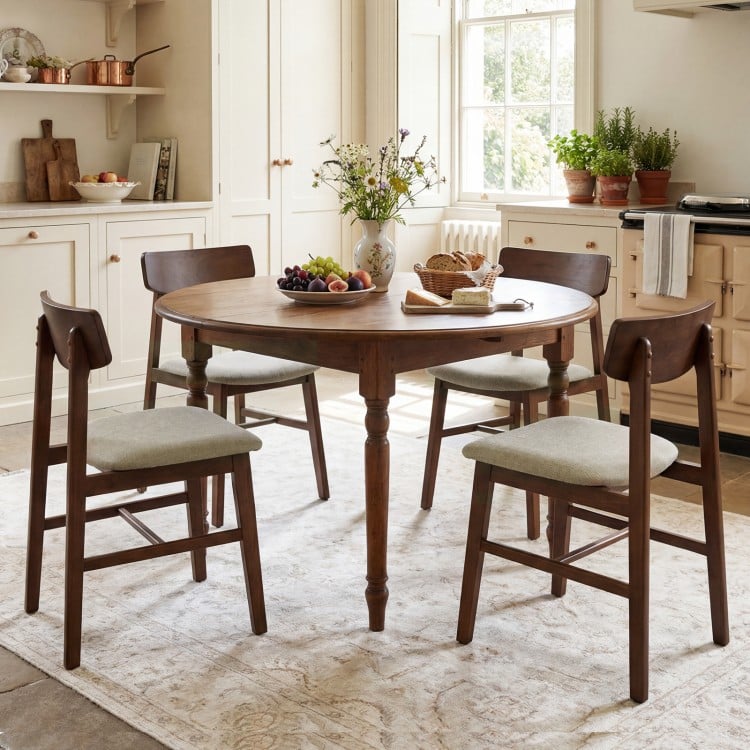 Round dining table with four walnut solid rubber wood chairs featuring curved backrests, perfect for a stylish kitchen.