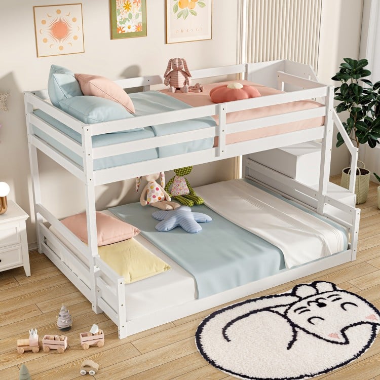 Low-profile solid wood twin over full bunk bed in white with storage stairs and open compartments for kids' room.
