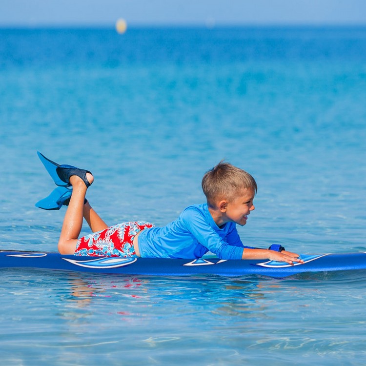 Child lying on a 6-foot foam surfboard in the ocean, perfect for beginners with a durable foam top and removable fins.