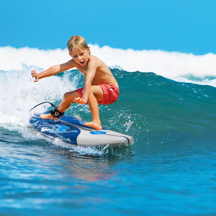 Child surfing on a 6 feet foam surfboard, featuring a durable foam top and removable fins, perfect for beginners.