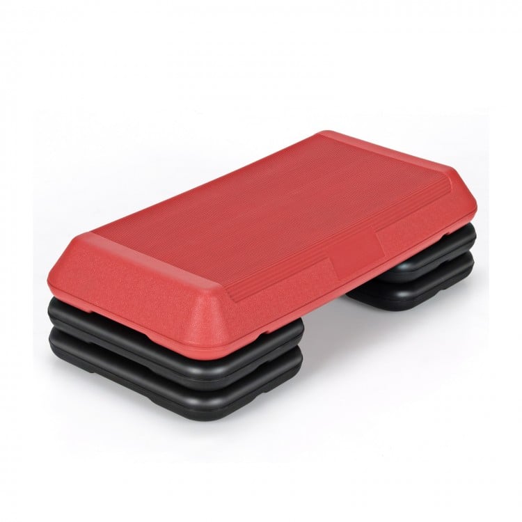 Adjustable red aerobic stepper platform with detachable risers for varied workout intensity, ideal for home or gym use.