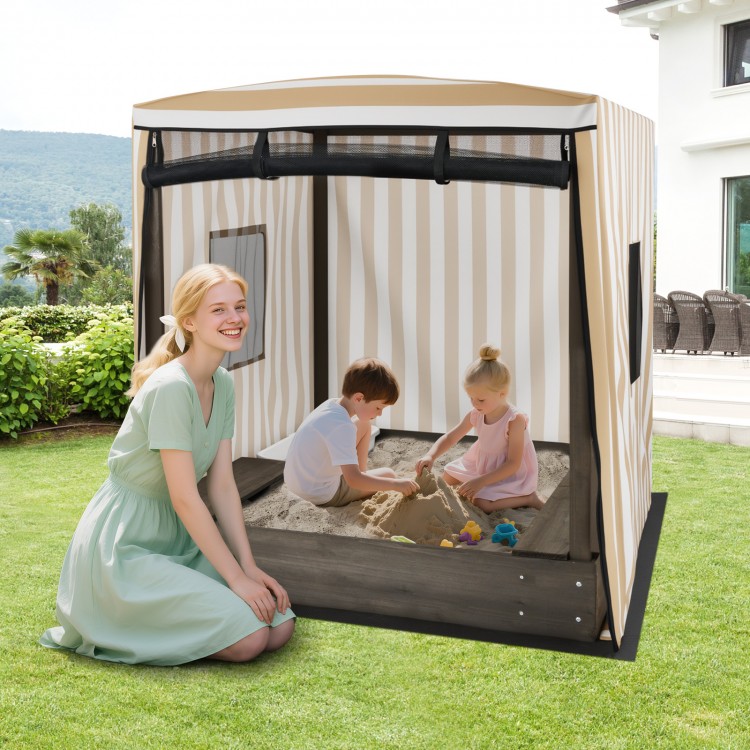Wooden sandbox with canopy for children, featuring roll-up curtains and built-in seats, perfect for outdoor play.