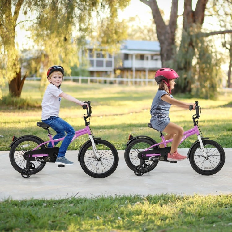 Two kids riding 18-inch pink bicycles with training wheels, featuring adjustable seats and dual brake systems for.