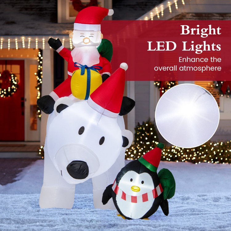 Inflatable Santa Claus riding a polar bear with a penguin, featuring bright LED lights for festive outdoor decoration.