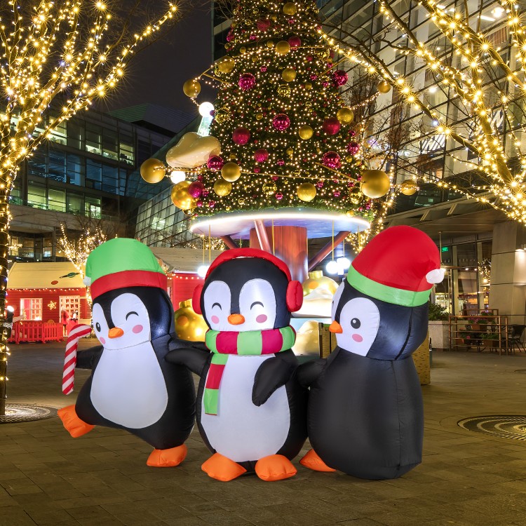 Inflatable Christmas penguins family with LED lights, wearing Santa hats and candy canes, perfect for festive displays.