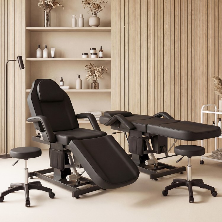 Tattoo chair with hydraulic stool in black, featuring adjustable backrest and footrest for client comfort in.