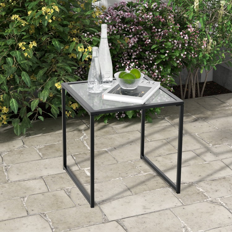 Square tempered glass side table with a sturdy metal frame, ideal for indoor and outdoor use on patios or balconies.