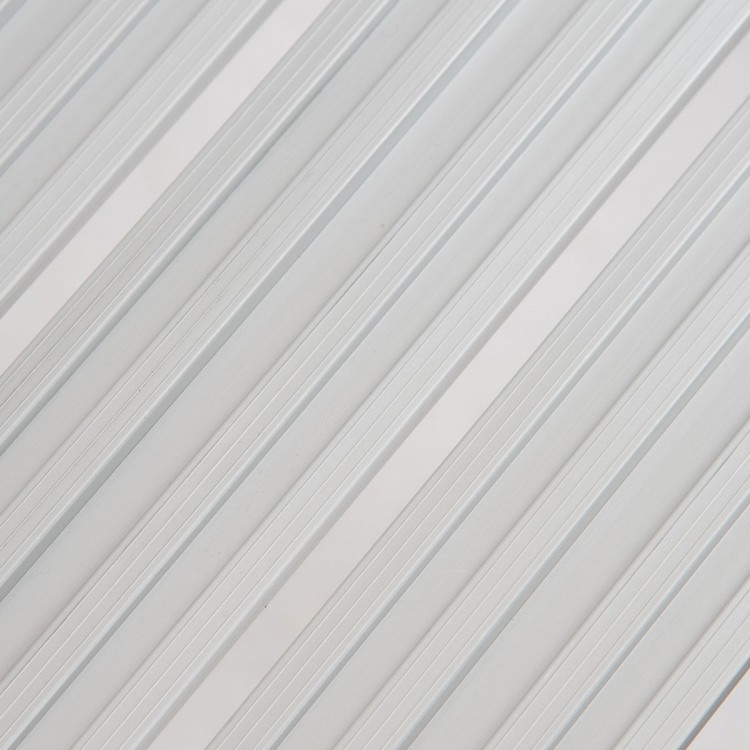 Close-up of the aluminum surface of a heavy-duty portable folding step ladder, designed for safety and stability.