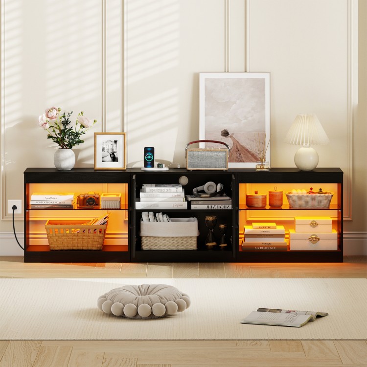 Black TV stand with RGB LED lighting, open shelves, and built-in power outlets for TVs up to 85 inches.