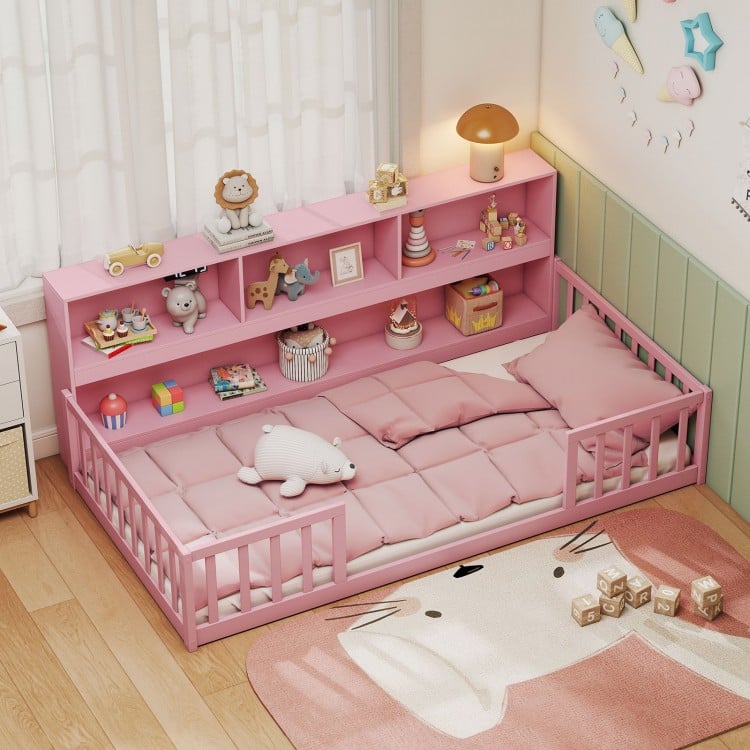 Twin size pink Montessori floor bed with integrated bookcase, perfect for kids' playtime and cozy resting.