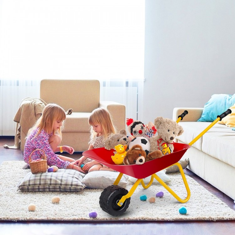 Red metal wheelbarrow filled with toys, perfect for kids to transport treasures during outdoor play.