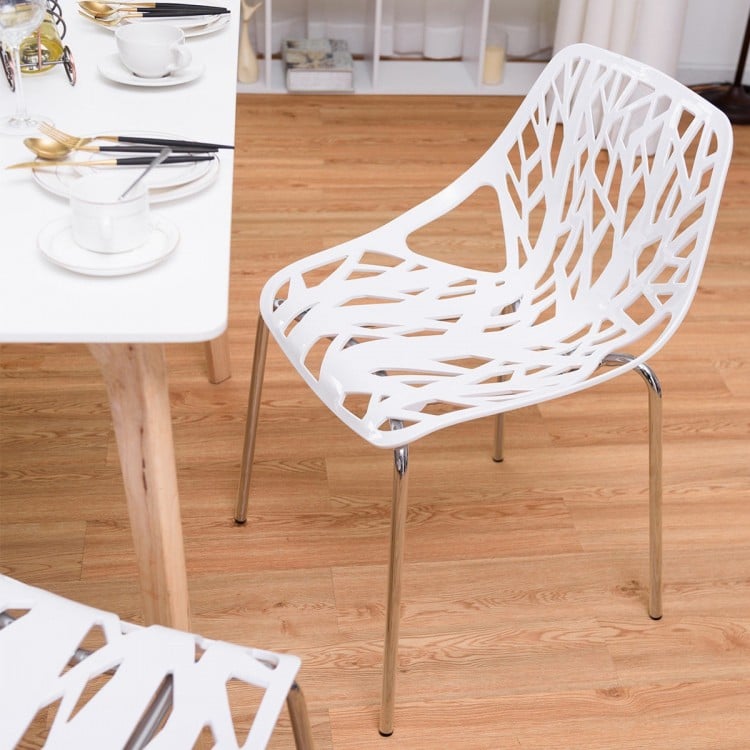 Single white accent dining chair with a cut-out tree design and chrome legs, perfect for stylish indoor dining.