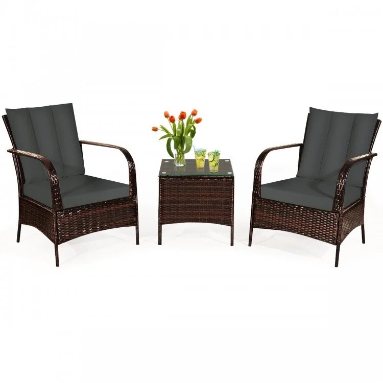 Two patio chairs with dark cushions and a glass table, part of a 6-piece rattan furniture set for outdoor relaxation.