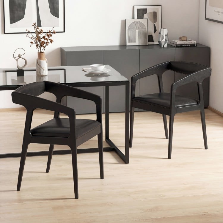 Set of 2 black upholstered armchairs with ergonomic backrest and padded seat, perfect for dining or relaxing.