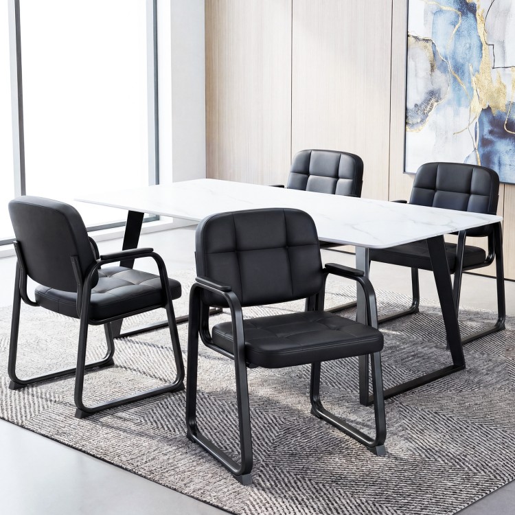 Set of four black leather office reception chairs with cushioned seats and ergonomic backrests for comfort in waiting.