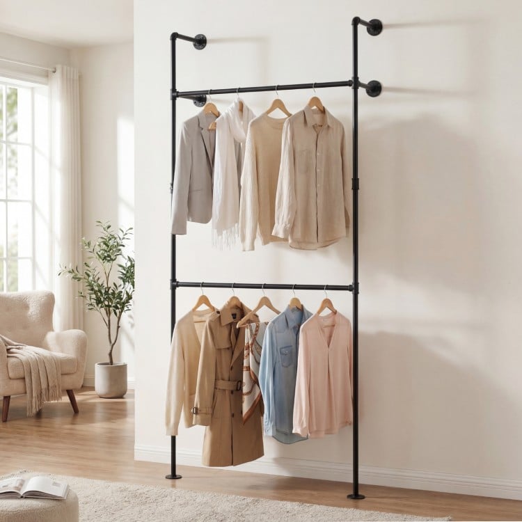 Wall-mounted black clothing rack with two hanging rods, designed for organizing coats and shirts in small spaces.