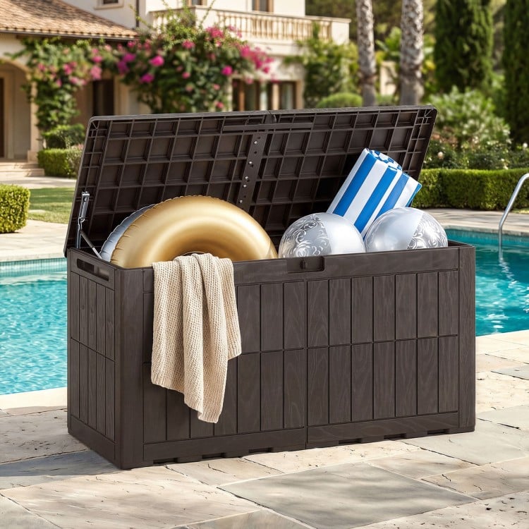 Dark brown waterproof lockable outdoor deck box with pool supplies, cushions, and a cozy blanket for outdoor use.