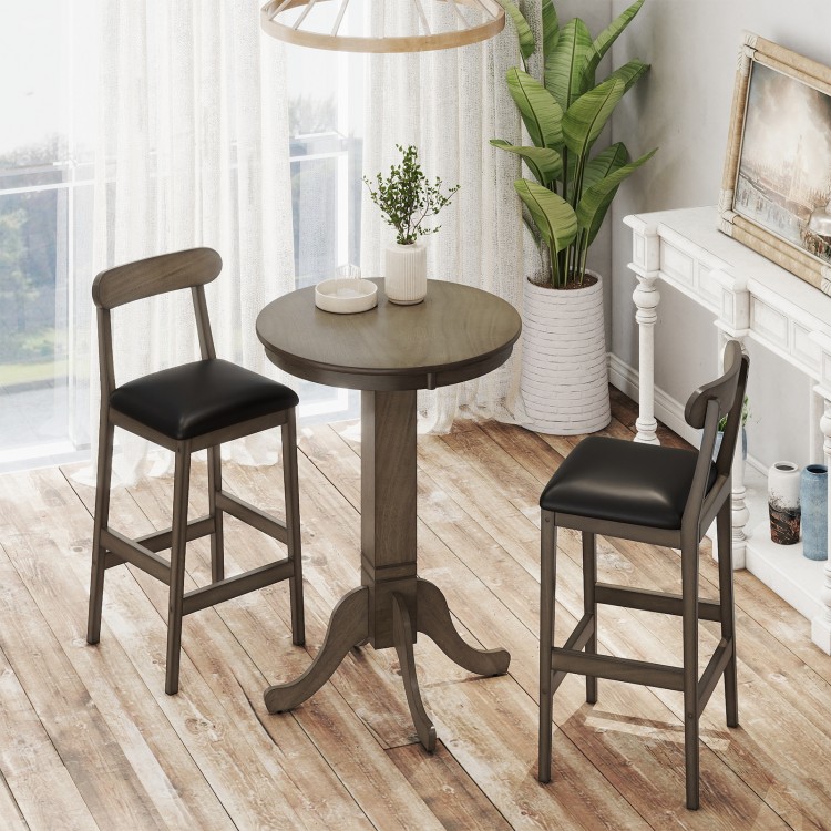 Round gray wood pub dining table with pedestal base, suitable for 2-4 people, in a rustic setting with two chairs.
