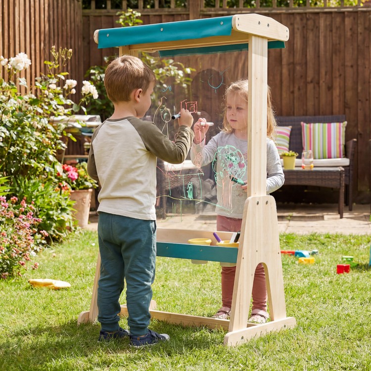 Kids using a wooden art easel with a transparent board and paper roll for creative outdoor play and art activities.