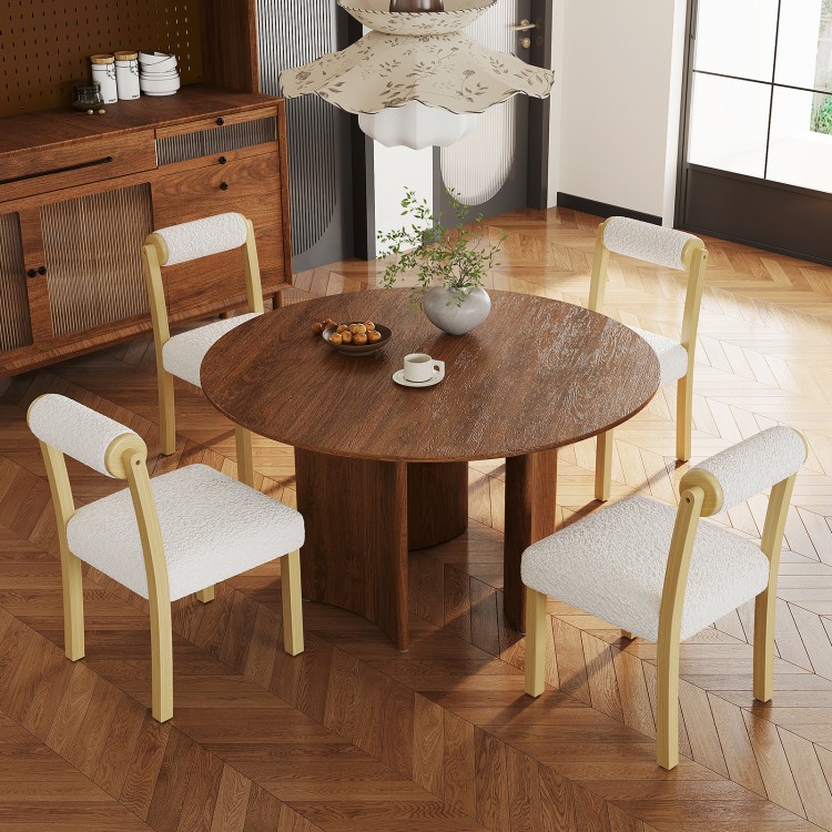 Round wooden dining table with four white faux sherpa chairs, showcasing rustic charm and modern elegance for dining.