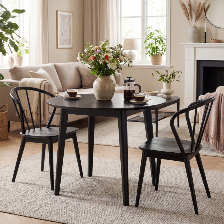 Black wooden dining chair set of 2 with high spindle backs, featuring wide seats for comfort in a stylish living space.