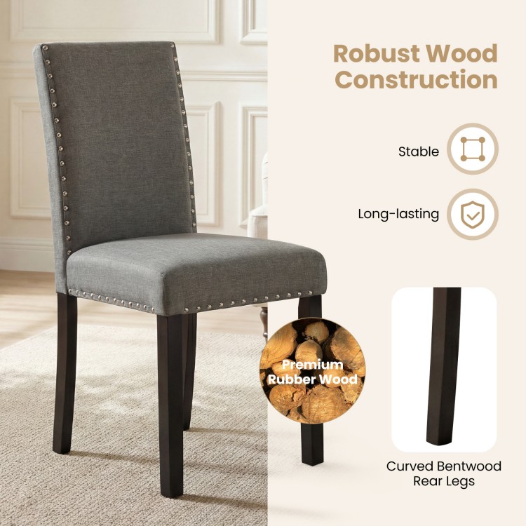 Wooden dining chair with curved back, rubber wood legs, and nailhead trim for stylish comfort in any setting.