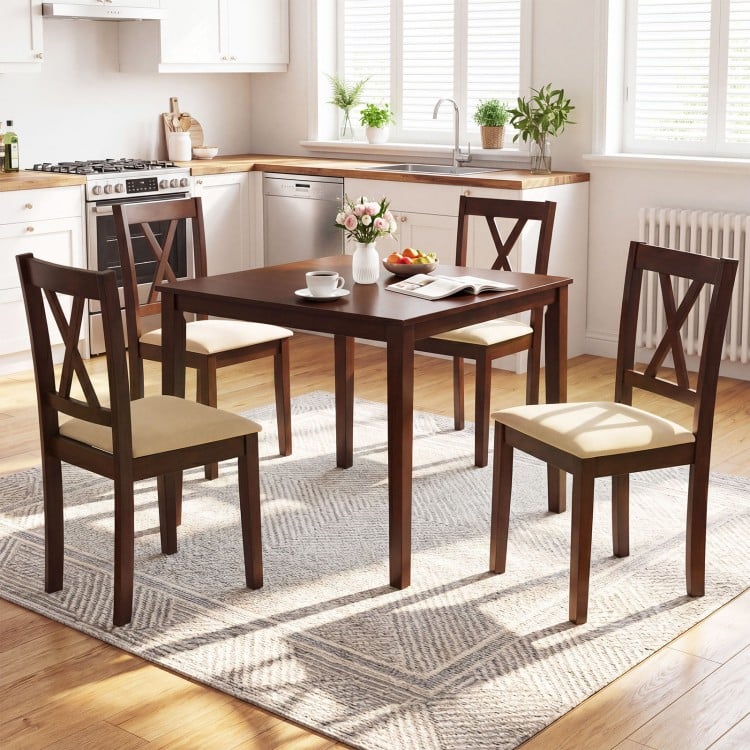 Walnut wooden dining table with four upholstered chairs, featuring ergonomic backrests for comfort in a kitchen setting.