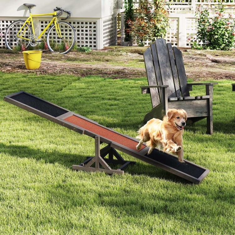 Wooden dog agility seesaw in gray for outdoor training, featuring a stable triangular base and high-traction surface.