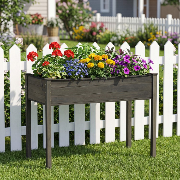Wooden raised vegetable garden bed in gray with colorful flowers, ideal for patio or backyard planting.