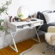 Modern white computer desk with X-shaped iron legs and two storage compartments, ideal for work or makeup in any room.